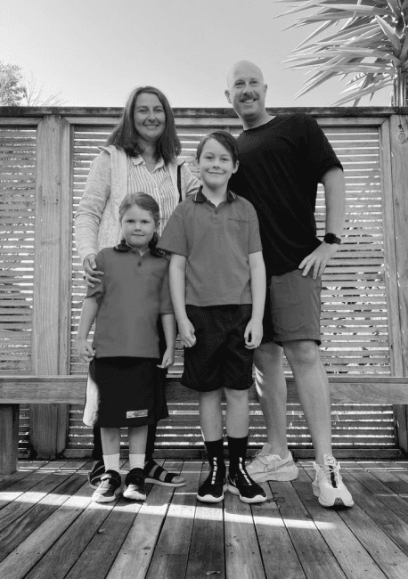 Logan standing with his wife and two children