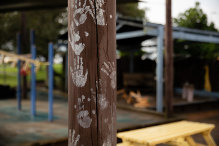 Children's painted handprints on wooden pole