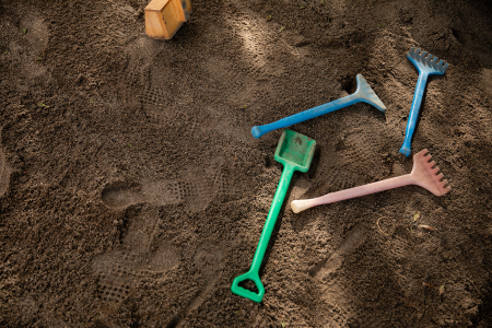 Sandpit with plastic shovels